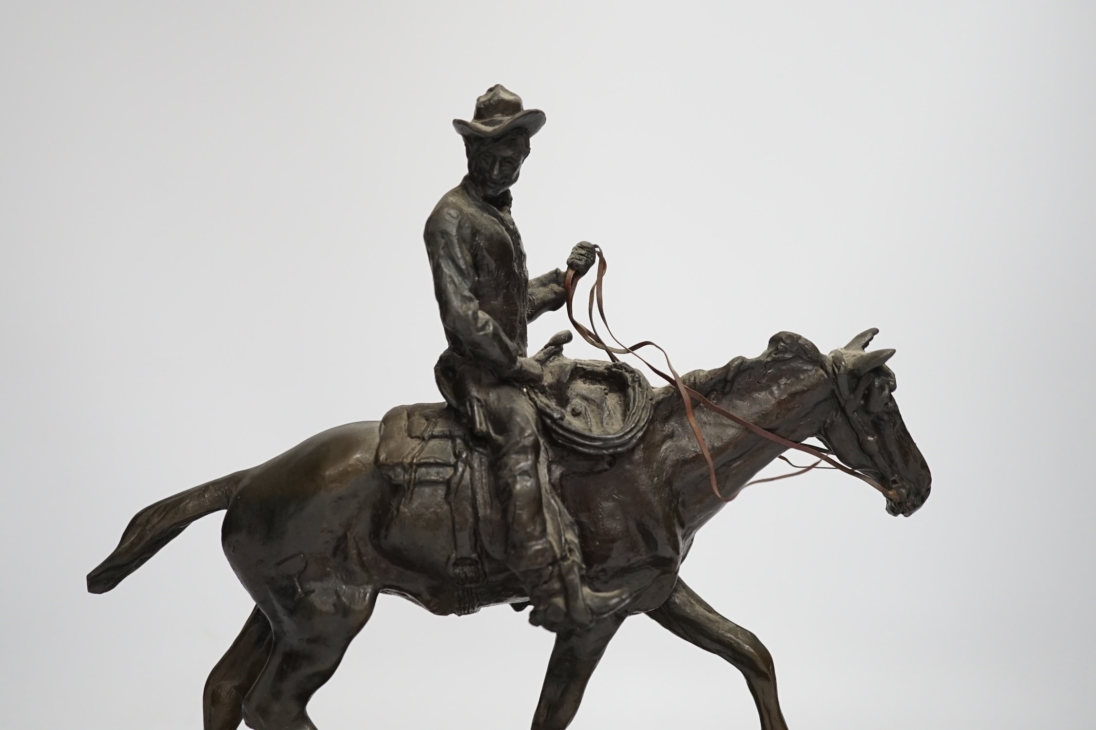 After Charles Marian Russell, a bronze group of Will Rogers, 29cm high